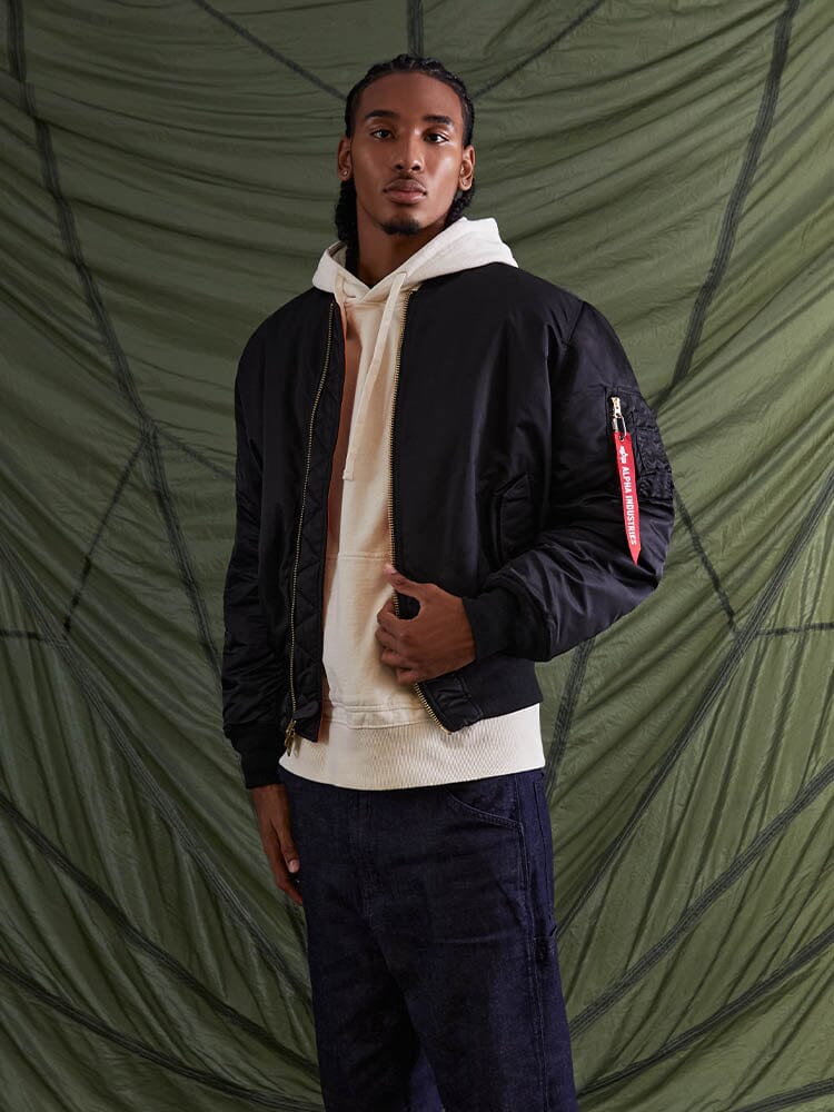 Front view of MA-1 Bomber Jacket (Heritage) in Black with male model. Knees up view. By Alpha Industries.