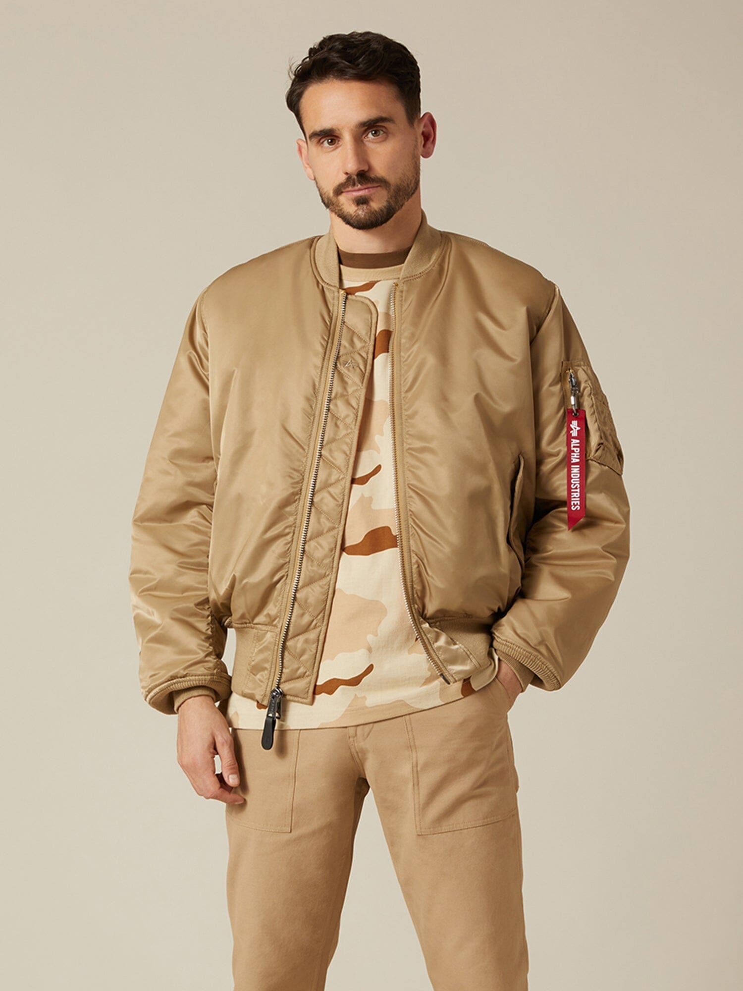 Front view of MA-1 Bomber Jacket (Heritage) in Khaki (Vintage) with male model. Knees up view. By Alpha Industries.