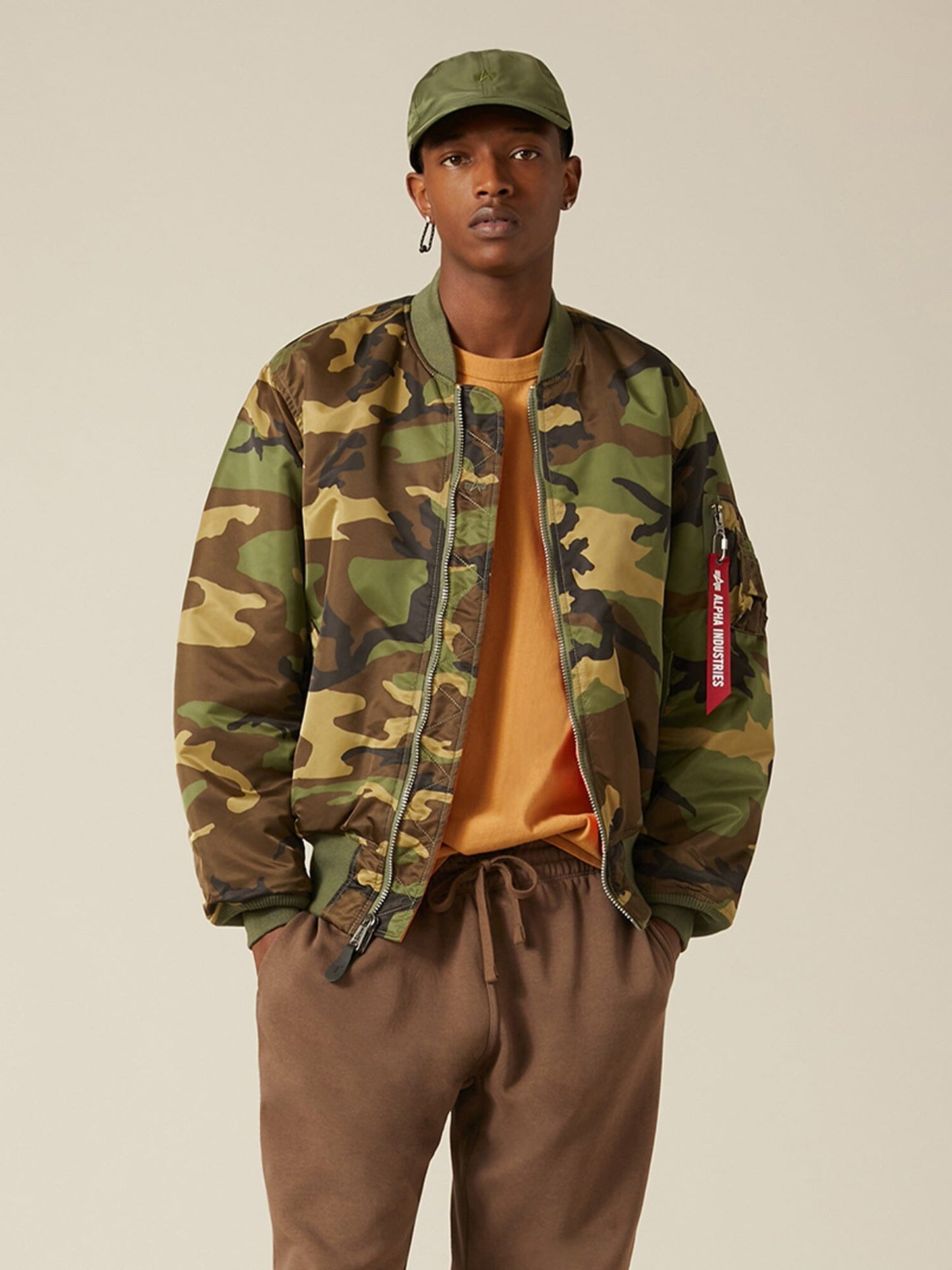 Front view of MA-1 Bomber Jacket (Heritage) in Woodland Camo with male model. Knees up view. By Alpha Industries.