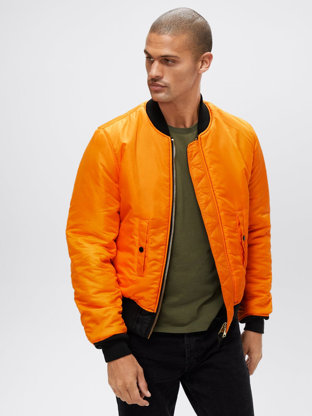 Three-quarter front view of orange reversible Alpha Industries MA-1 Bomber Jacket Slim Fit showing ribbed cuffs and waistband.