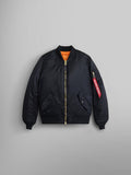 Alpha Industries MA-1 Bomber Jacket Womens in black with gold zipper, orange lining, and red Remove Before Flight tag on left sleeve.