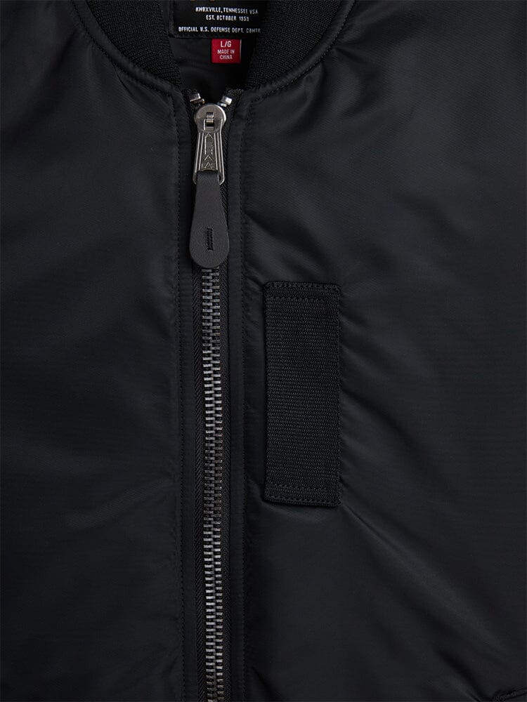 Alpha Industries MA-1 Mod Bomber Jacket in black with metal zipper, fabric pull tab, rectangular stitched front detail, utility pocket.