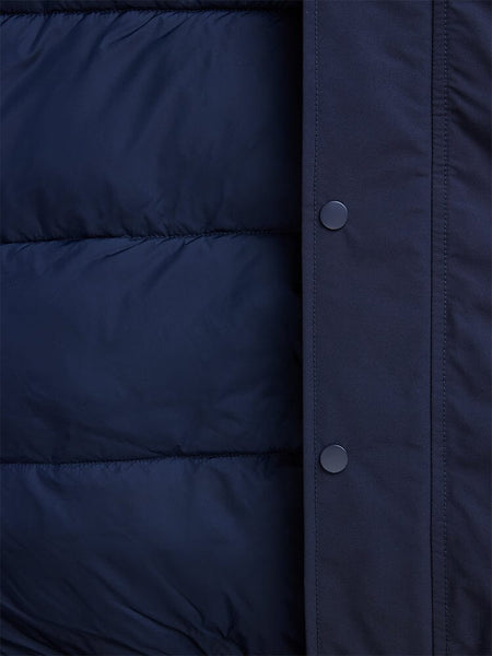 Close-up of a blue padded N-2B Altitude Parka from Alpha Industries, featuring button snaps on the right edge and a water-resistant finish.