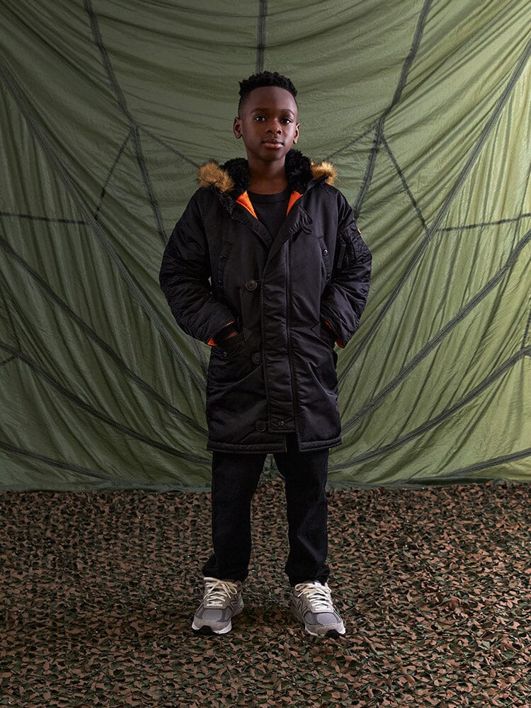 Alpha Industries N-3B Parka Youth, black with fur-trimmed hood, water-resistant fabric, front closures.