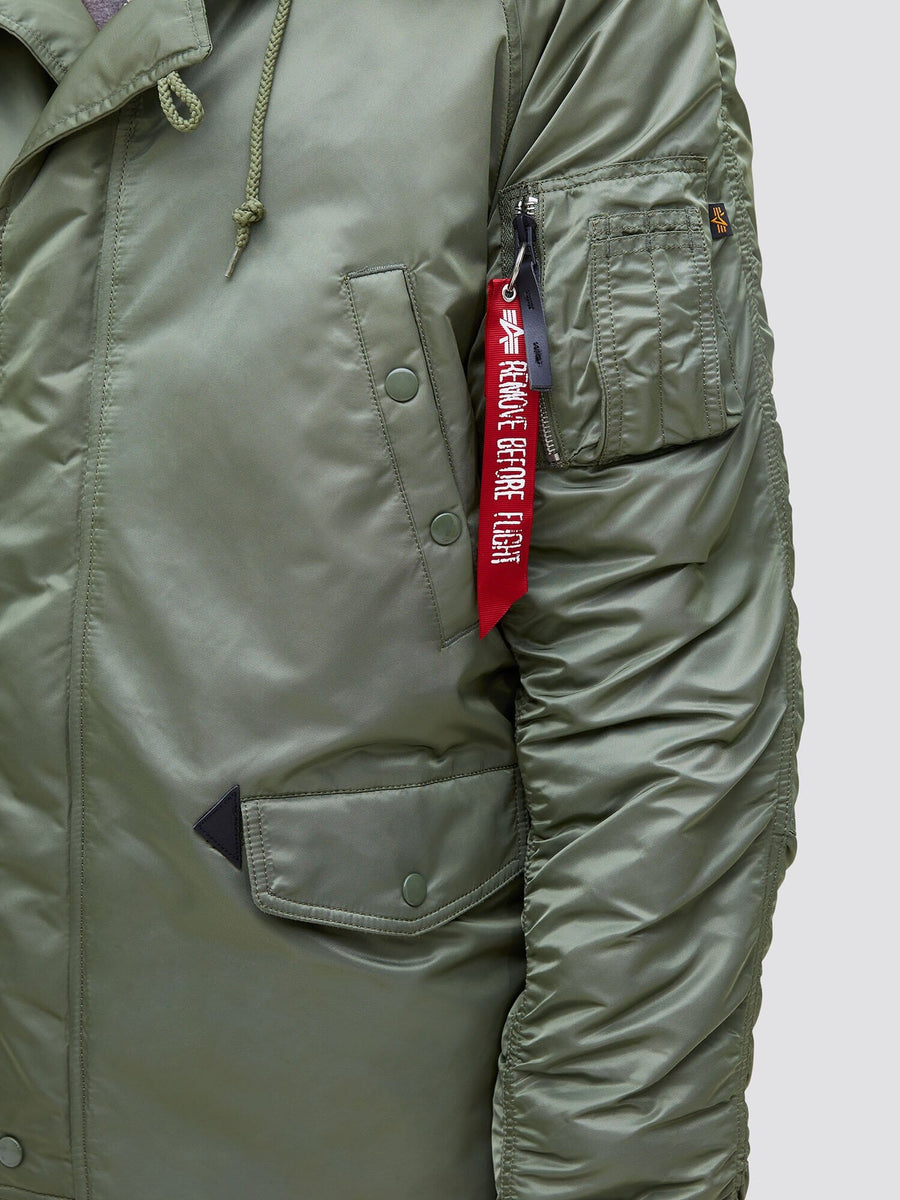 Alpha Industries N-3B Slim Gen I Parka, green bomber jacket with zippered sleeve pocket, red “Remove Before Flight” tag, water resistant.