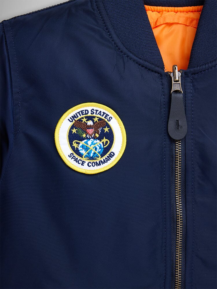 Alpha Industries NASA MA-1 Bomber Jacket, navy blue with front zipper, MA-1 utility pocket, and embroidered United States Space Command patch on left chest.
