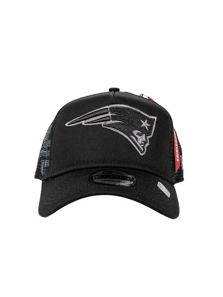 The New England Patriots X Alpha X New Era 940 Cap from Alpha Industries showcases a black mesh design with a stylized logo of a profile wearing a tricorne hat on the front, marrying New Era craftsmanship with classic flair.