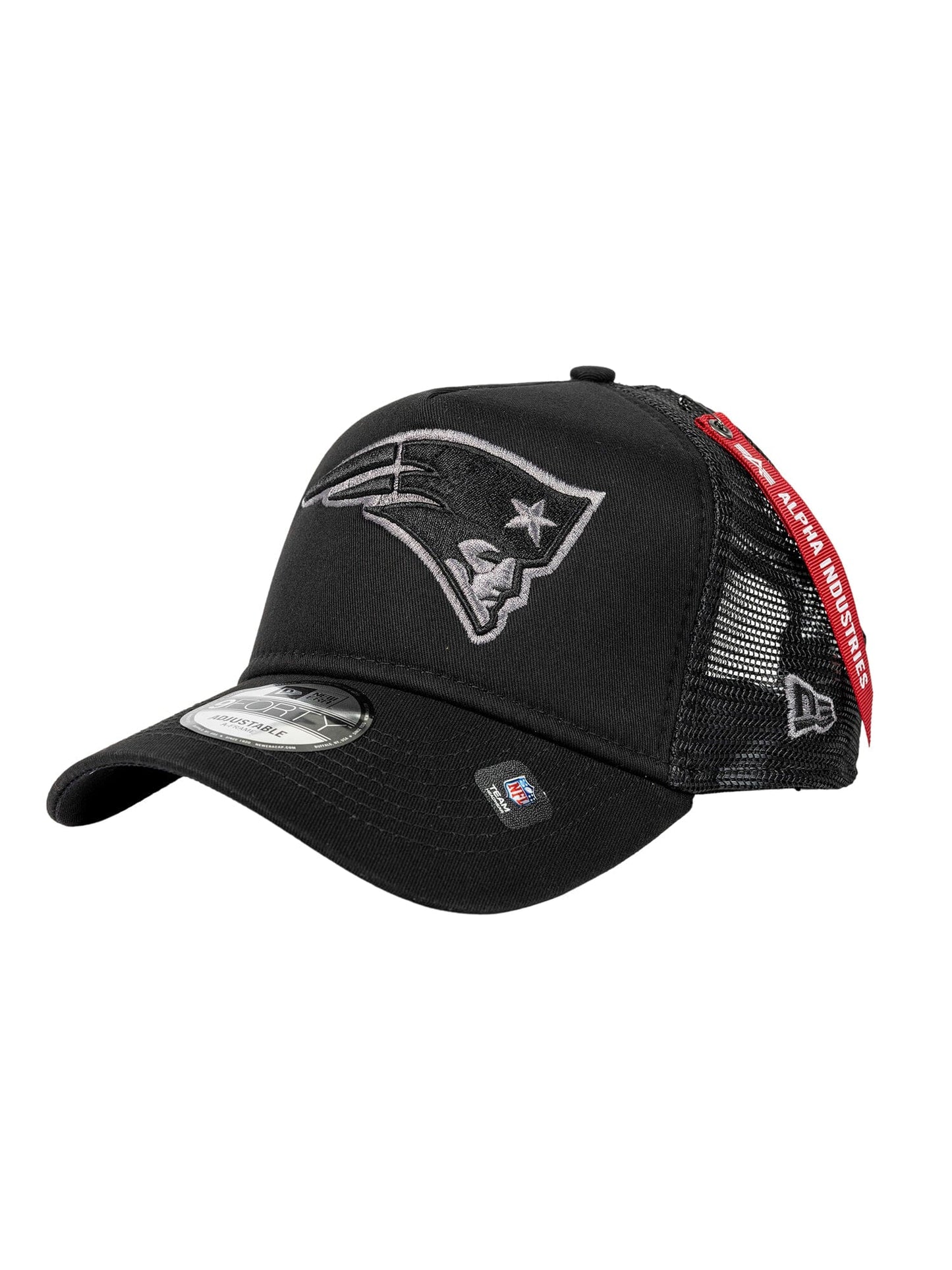 The New England Patriots x Alpha x New Era 940 Cap by Alpha Industries features a stylized face logo on the front, mesh back panels for breathability, and a distinctive red tag on the side, all in black.