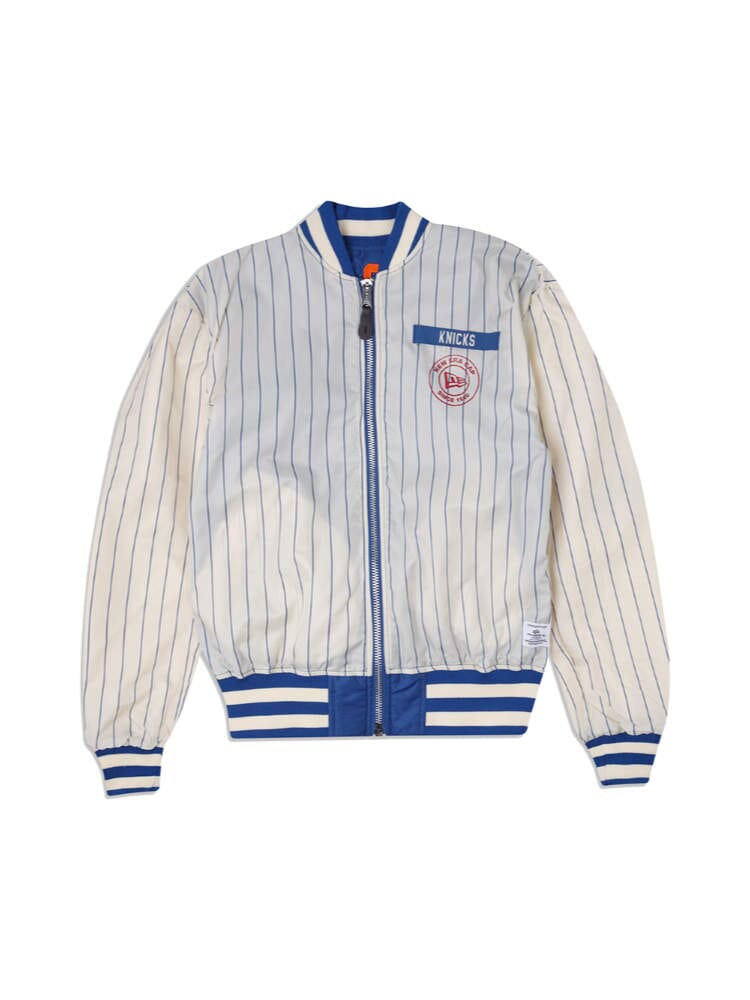 Introducing the New York Knicks X Alpha x New Era L-2B Bomber Jacket, a vintage-inspired piece from Alpha Industries and NE-NBA. This exclusive jacket features vertical pinstripes and showcases "Knicks" on the chest, complemented by a blue collar, cuffs, and waistband. Enhanced with authentic team patches.