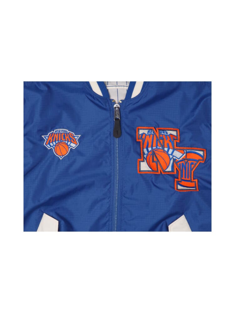 New York Knicks x Alpha x New Era L-2B Bomber Jacket by Alpha Industries comes with New York Knicks logos on the chest, basketball motifs, team initials, and fashionable team patches.