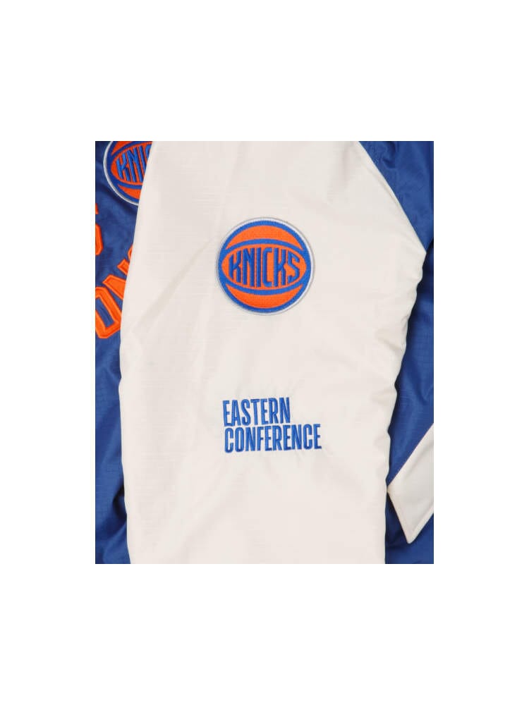 Introducing the New York Knicks X Alpha X New Era L-2B Bomber Jacket by Alpha Industries in a classic white and blue color scheme. This stylish bomber jacket features the Knicks logo, Eastern Conference text, and team patches—an ideal addition to any fan's wardrobe.