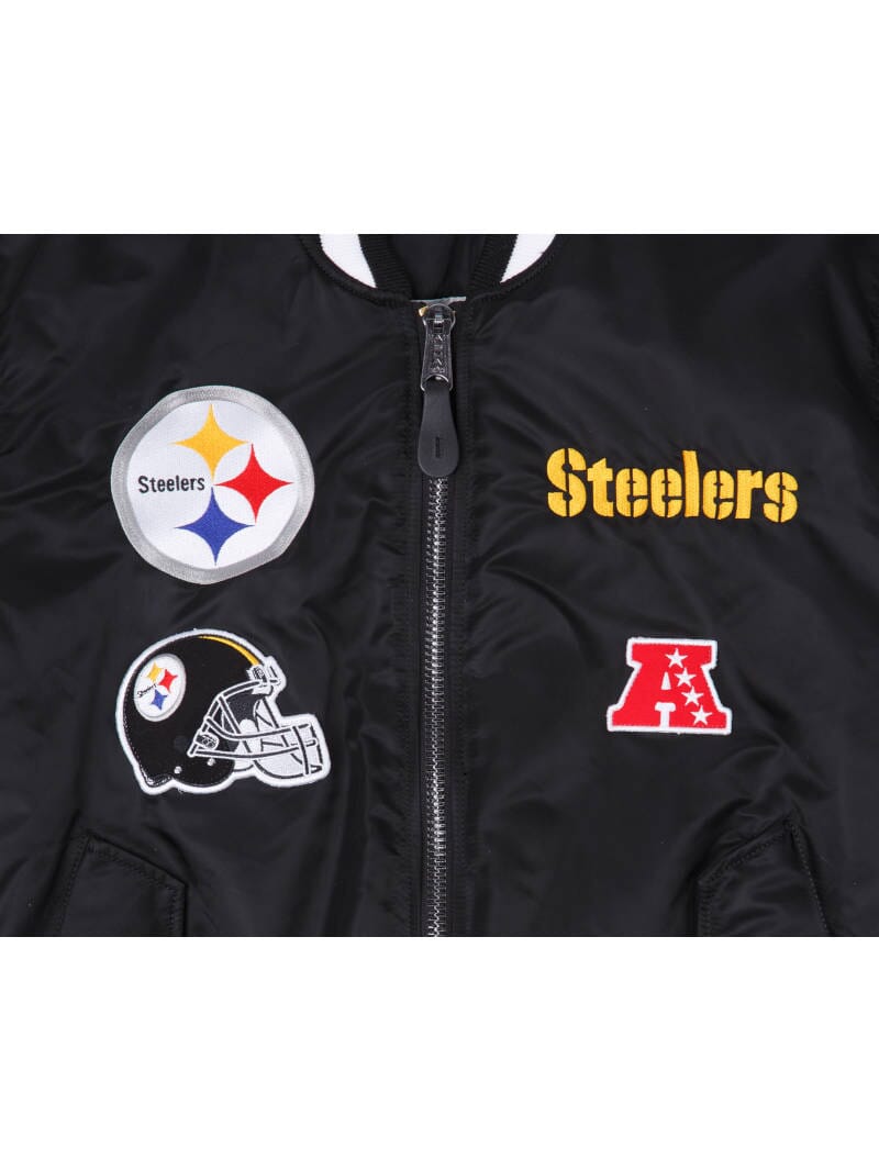 This reversible Pittsburgh Steelers bomber jacket, officially known as the Alpha Industries MA-1 Bomber Jacket in collaboration with New Era NFL, displays team patches, including the iconic Steelers logo, an NFL helmet, and the AFC badge.
