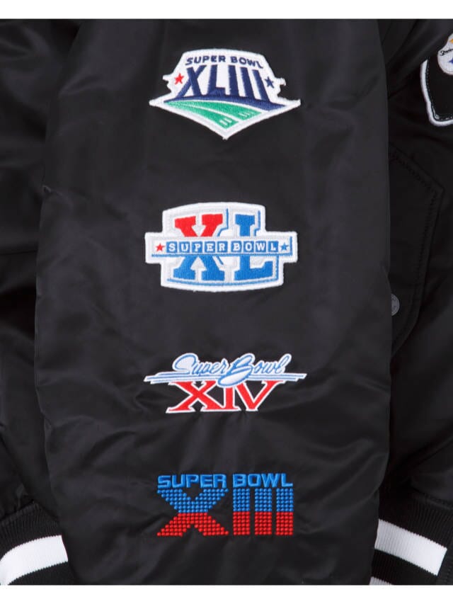 The Pittsburgh Steelers X Alpha X New Era MA-1 Bomber Jacket by Alpha Industries features embroidered Super Bowl logos XLVIII, XL, XIV, and XIII in vibrant colors and designs on its reversible bomber style.
