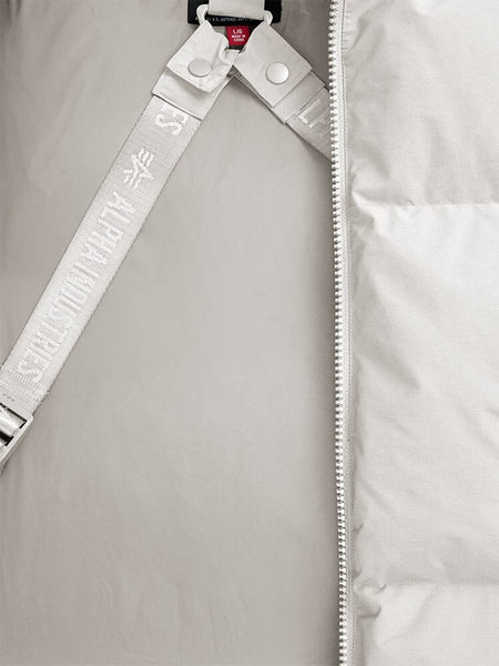 Close-up of the Alpha Industries Puffer Parka, showcasing a limestone padded design with a zipper and partially visible strap featuring embossed text.