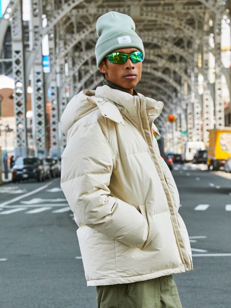 A person wearing the Puffer Parka in limestone by Alpha Industries.