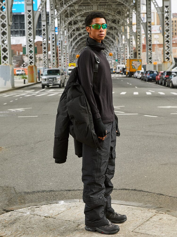 A person wearing the Puffer Parka by Alpha Industries, featuring interior backpack straps.