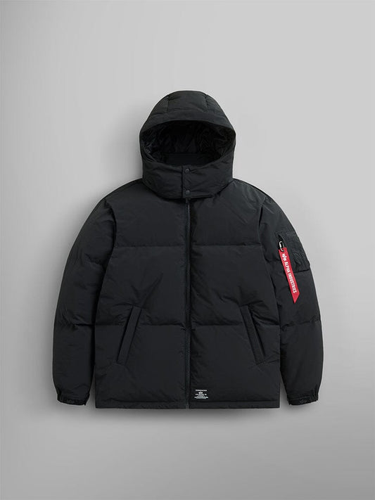 The black Puffer Parka by Alpha Industries is showcased with a removable hood and adjustable drawcords, along with a distinctive red tag on the sleeve.