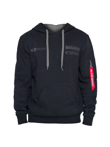 The Tampa Bay Buccaneers X Alpha Industries X New Era Hoodie by Alpha Industries comes in black and features a gray hood lining along with a front logo that reads "Alpha," celebrating the Tampa Bay Buccaneers NFC South Division. The hoodie includes unique flight tag branding, with the red zipper pull on the sleeve labeled "Remove Before Flight," highlighting the signature Alpha Industries x New Era style.